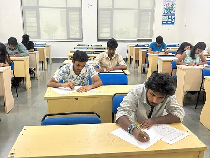 Students writing at their desks in a classroom at Amity University Kolkata