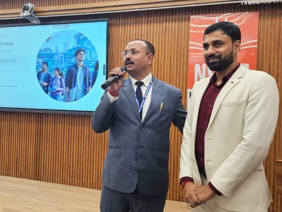A faculty member speaking alongside Dr. Sabyasachi Saha at the NSHM Inauguration 2026