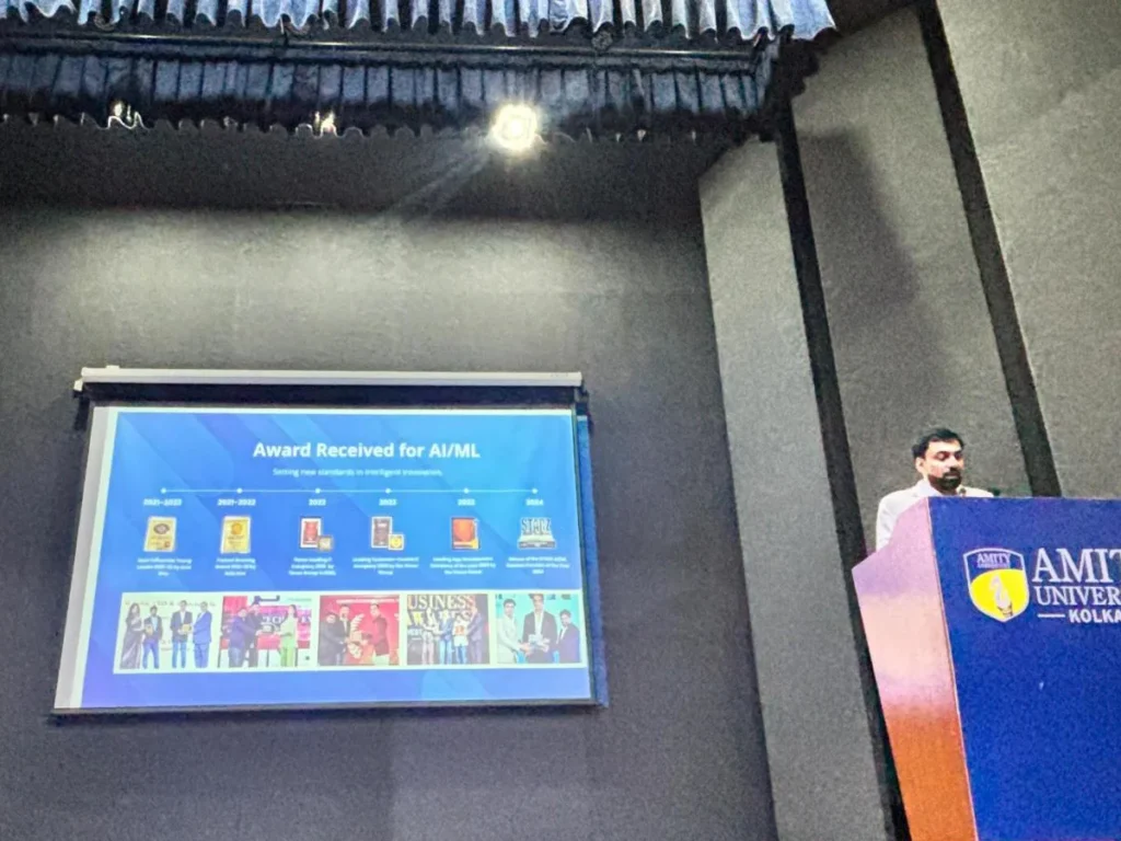 Dr. Sabyasachi Saha presenting slides from the podium on stage at Amity University Kolkata