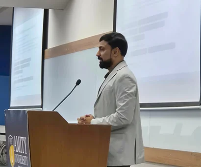 Dr. Sabyasachi Saha presenting from the lectern at the Amity University seminar on data analytics with AI