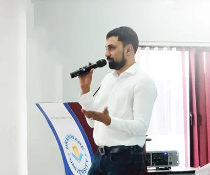 Dr. Sabyasachi Saha speaking with a microphone at Brainware University, Barasat