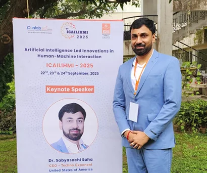 Dr. Sabyasachi Saha standing beside the ICAILIHMI 2025 keynote speaker standee at NSHM, Durgapur