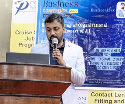 Dr. Sabyasachi Saha speaking into a microphone at the lectern, Pailan College of Management and Technology