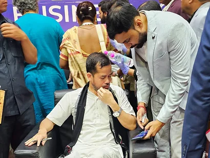 Dr. Sabyasachi Saha speaking with a seated guest at the Tripura Business Conclave 2026