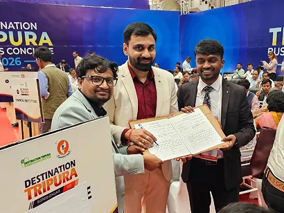 Dr. Sabyasachi Saha holding a signed document with two delegates at the Destination Tripura Business Conclave 2026